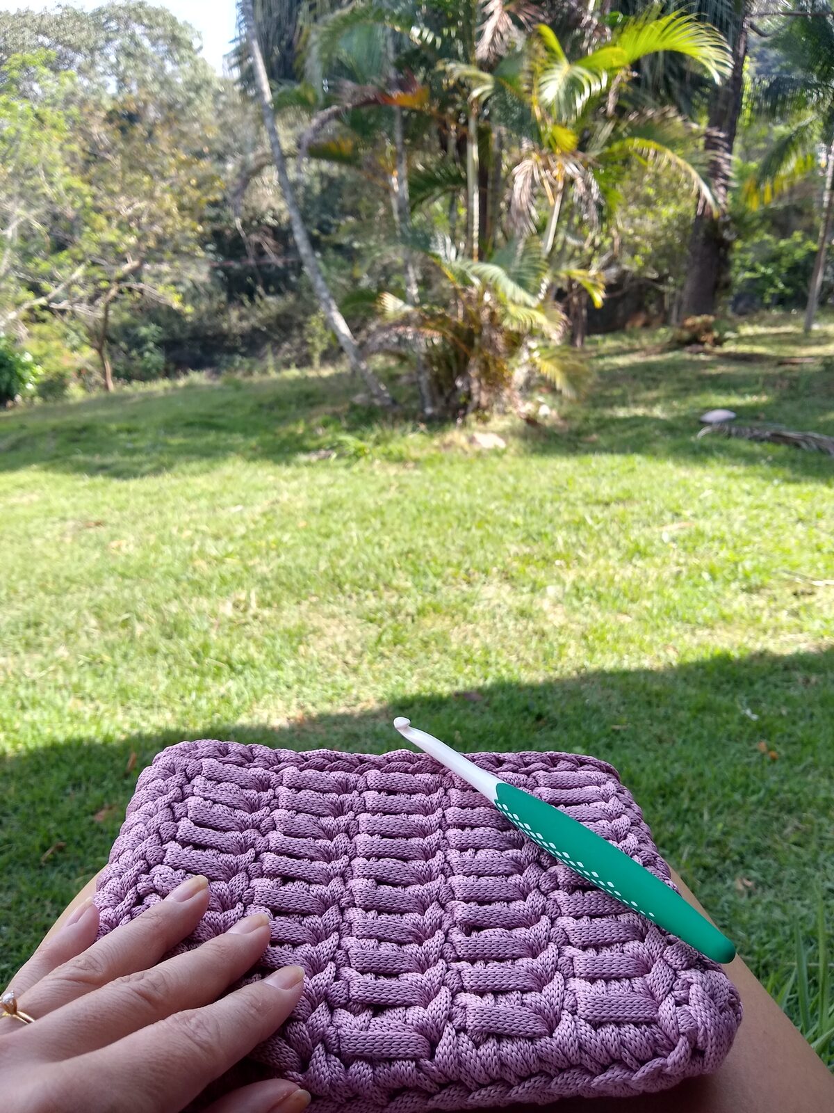 Clutch lilás em fio de malha com textura de cesto, ao ar livre