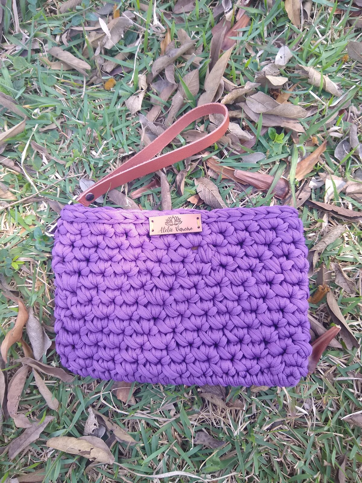 Clutch roxa em fio de malha com alça de couro